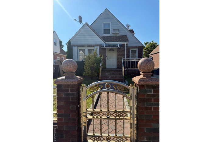 Bungalow-style home with a gate, brick siding, and a fenced front yard