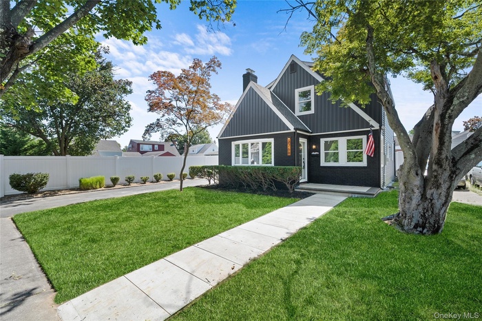 View of front of property with a chimney, board and batten siding, and brick siding