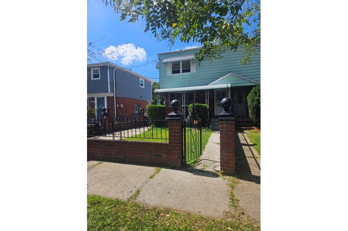 Traditional-style home featuring a gate and a fenced front yard