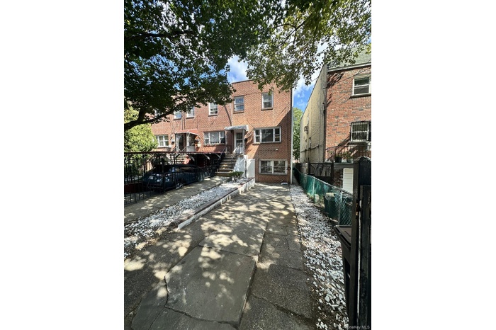 Back of house featuring a fenced front yard and brick siding