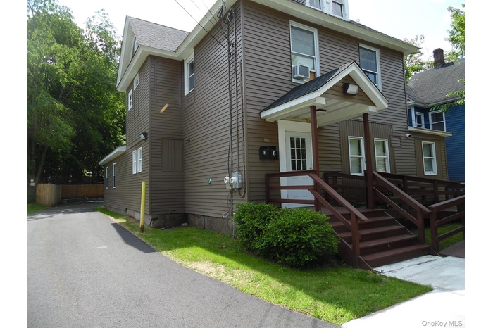 American foursquare style home with roof with shingles