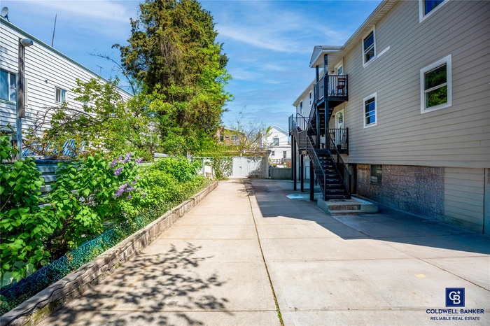 View of home's exterior with fence, a balcony, and stairway