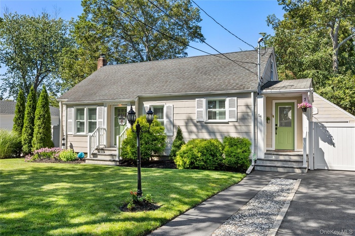 View of front of house featuring a chimney, a front yard, and roof with shingles