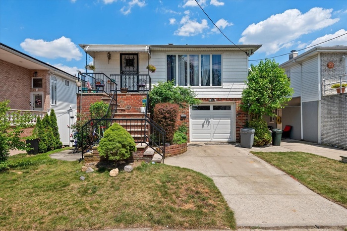 View of front of house featuring a garage, concrete driveway, a front yard, and brick siding