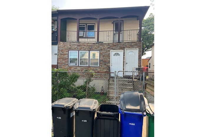 View of front of house with a fenced front yard, a gate, a patio, and a balcony