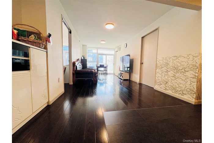 Hall with dark wood finished floors and a wall of windows