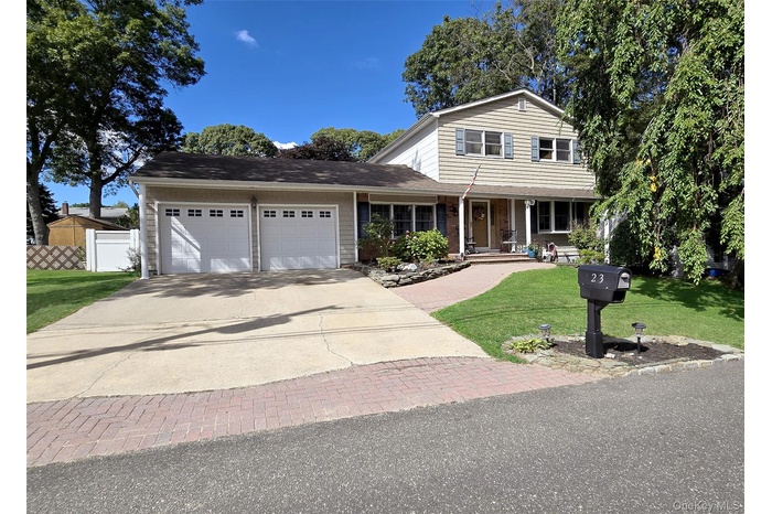 Traditional-style home with covered porch, driveway, and a garage