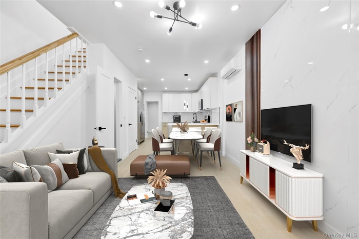 Living area with recessed lighting, a wall mounted AC, light wood-type flooring, stairs, and a chandelier