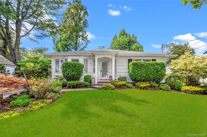 View of front of home featuring a front lawn and roof with shingles