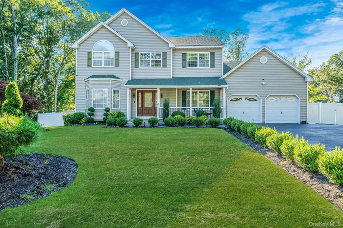 View of front of home with a porch, driveway, and roof with shingles