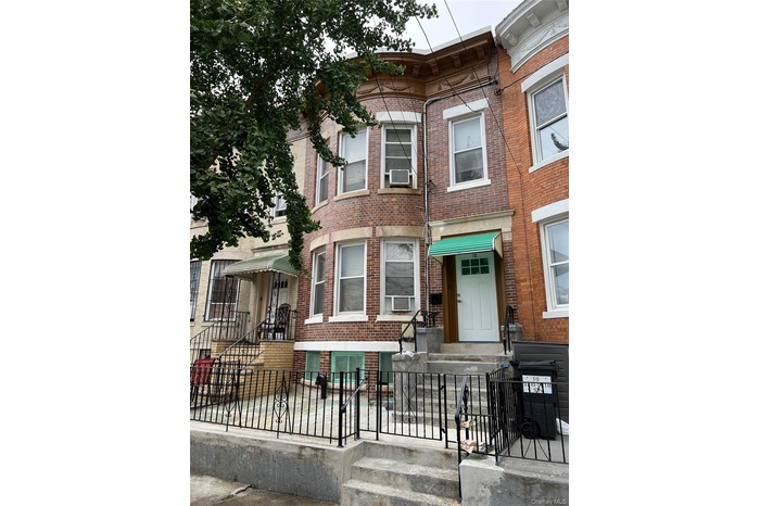 Italianate home featuring brick siding and a fenced front yard
