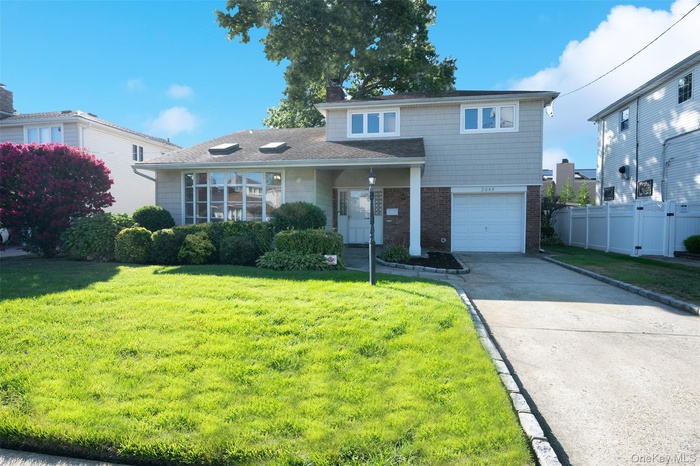 Avalon Split house featuring brick, siding, driveway, an attached garage