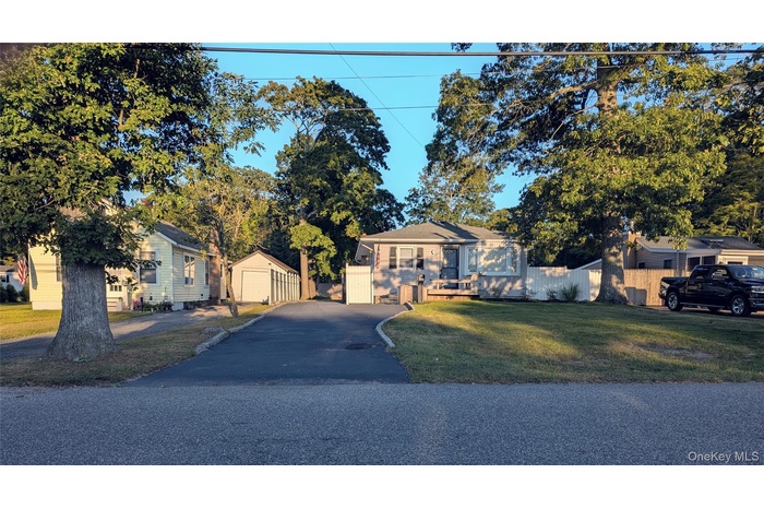 View of front facade with an outbuilding, driveway, and a garage