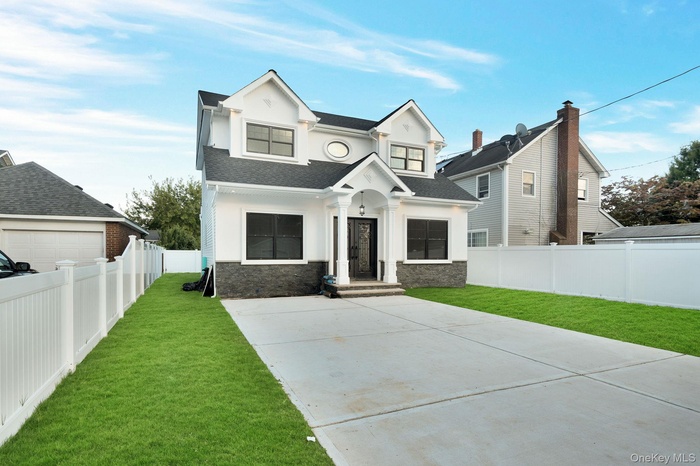 View of front facade featuring stone siding and a shingled roof