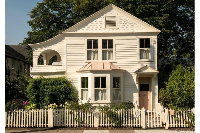 View of front of property with a standing seam roof, a metal roof, and a fenced front yard
