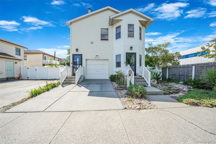 View of front of house with driveway, an attached garage, and board and batten siding