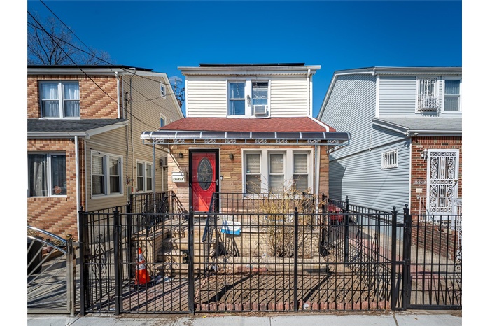 View of front facade with a fenced front yard and cooling unit