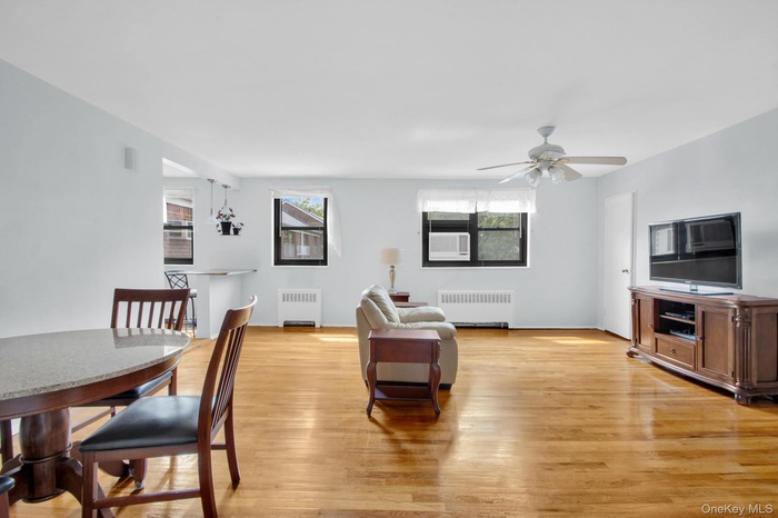 Living area featuring light wood-style floors, plenty of natural light, and radiator