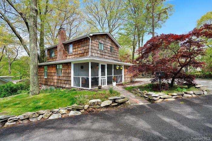 Back of property with a sunroom and a chimney