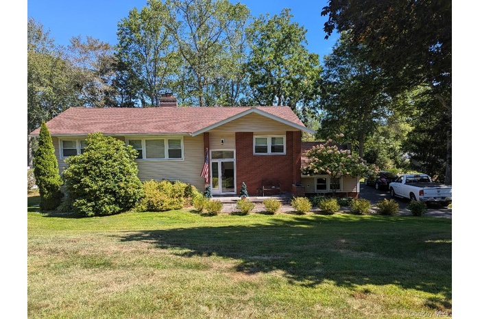 View of front of house with a front yard and a chimney