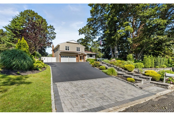 View of front of property with asphalt driveway and an attached garage