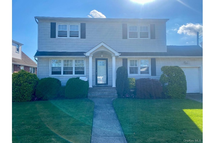 View of front of home featuring a garage and a front yard