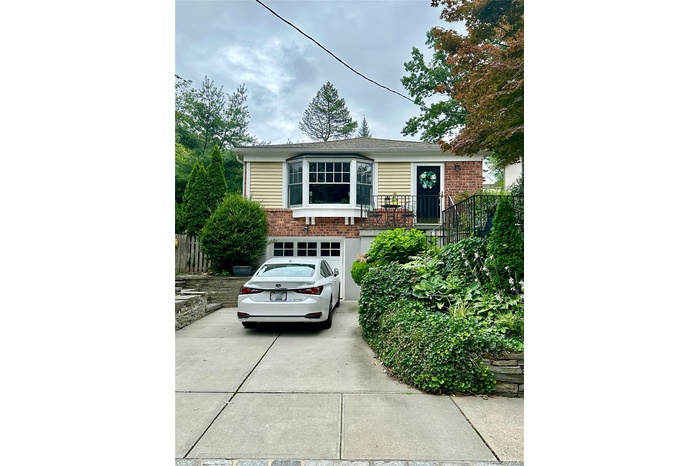 View of front of property with brick siding, concrete driveway, and a garage