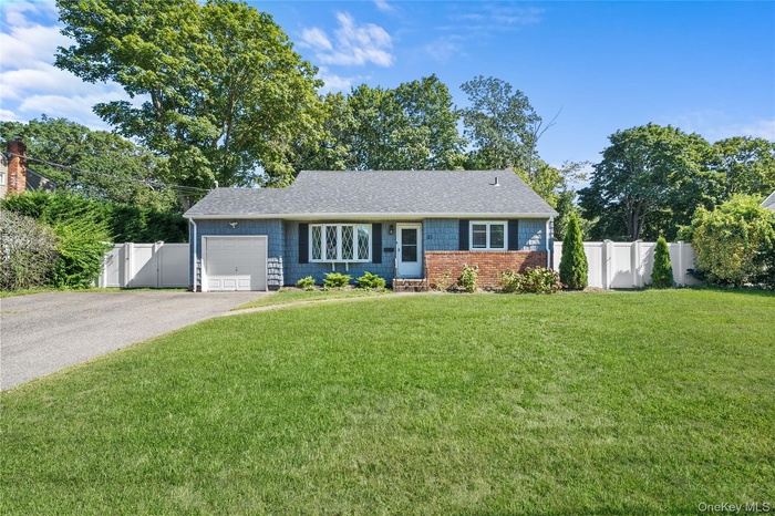 Ranch-style home with a gate, driveway, an attached garage, and roof with shingles