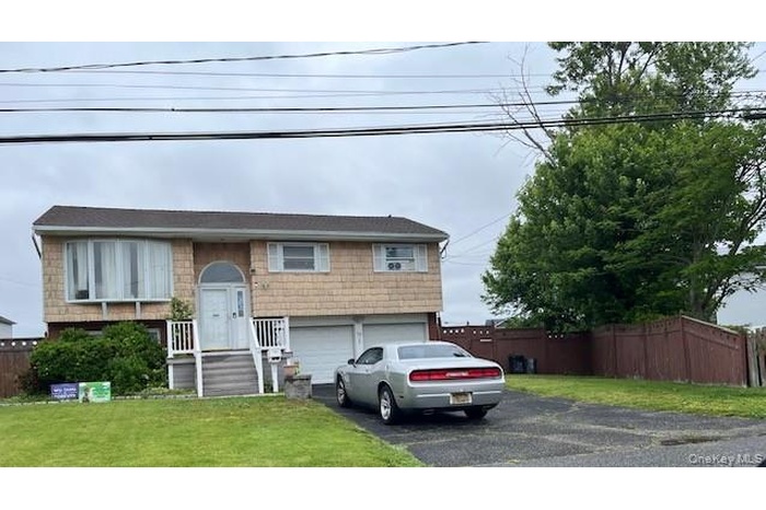 Split foyer home featuring driveway and a garage