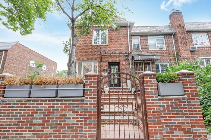 View of front of home featuring a gate, brick siding, and a fenced front yard