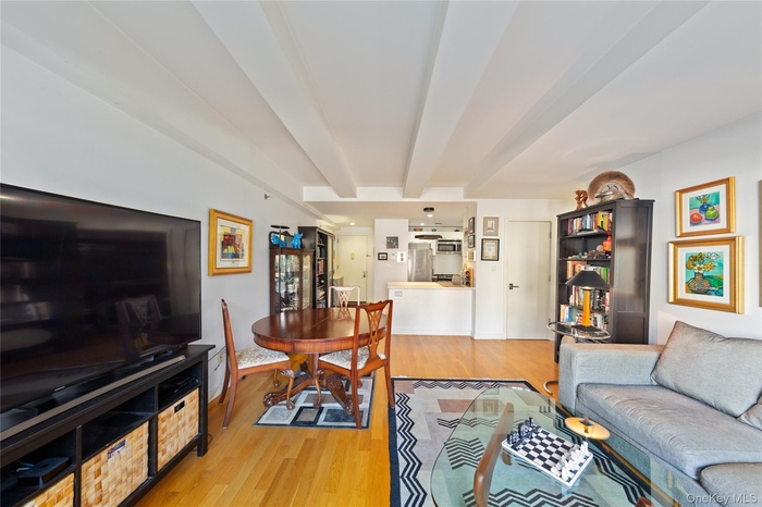 Living area featuring beamed ceiling and light wood-type flooring