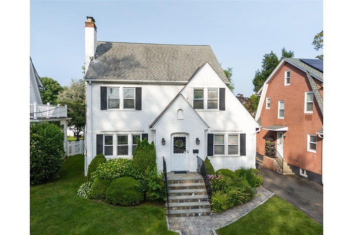 View of front of property featuring a chimney and roof with shingles