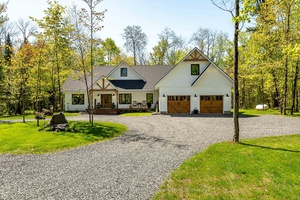 Welcome to this sprawling executive bungalow, built in 2022 and beautifully set on nearly 5 acres of lush, level land.