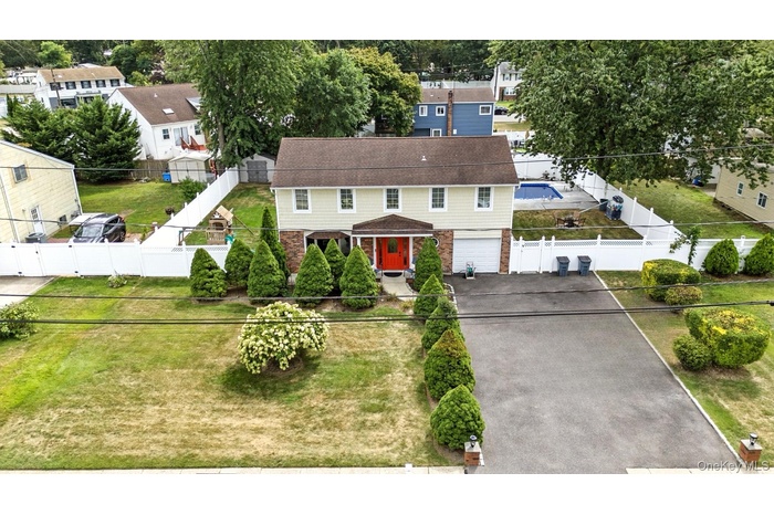 View of front of home with asphalt driveway, brick siding, a residential view, and a garage