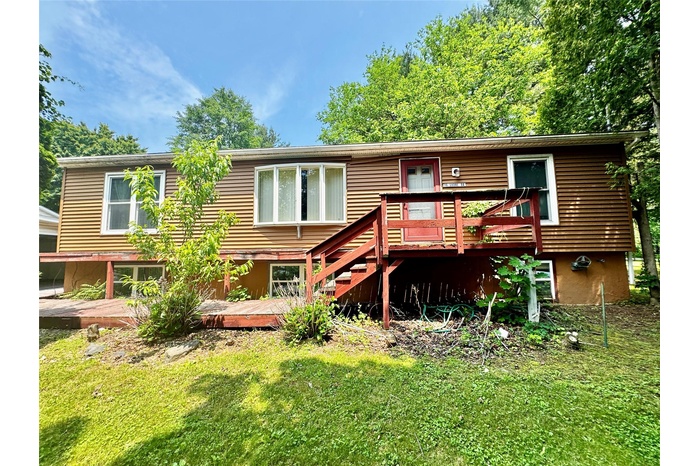 Back of property with a deck and a lawn