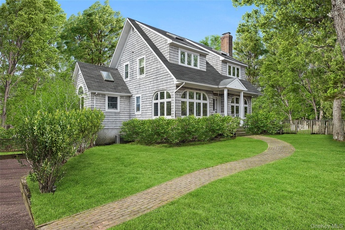 Back of property featuring a lawn, a chimney, fence, and roof with shingles