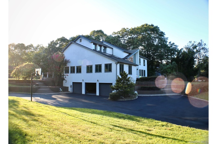 View of home's exterior with an attached garage, asphalt driveway, and a lawn