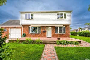 Experience timeless elegance in this distinguished Colonial home, graced with a striking red brick facade and charming front porch.