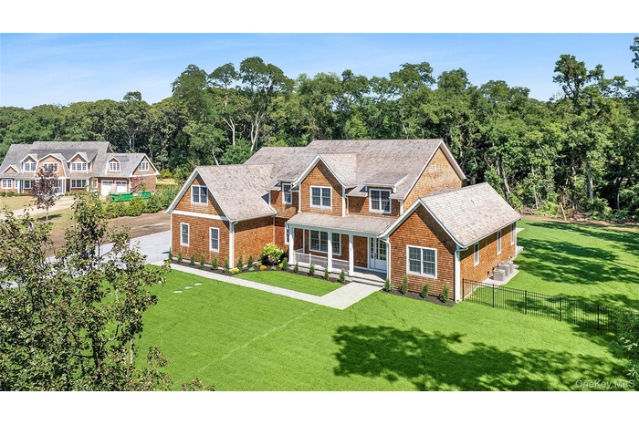 Shingle-style home featuring a porch and roof with shingles