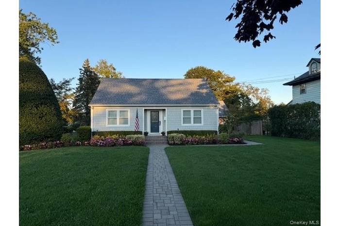 New england style home featuring a front lawn