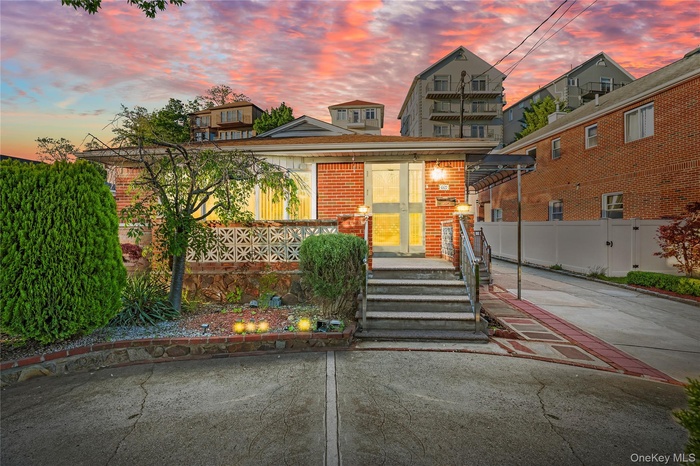 View of front of house with brick siding and a gate