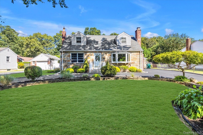 Cape cod home featuring stone siding and a chimney