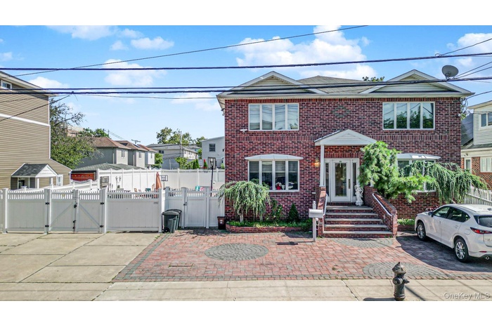 Traditional-style home with a gate, brick siding, and a residential view