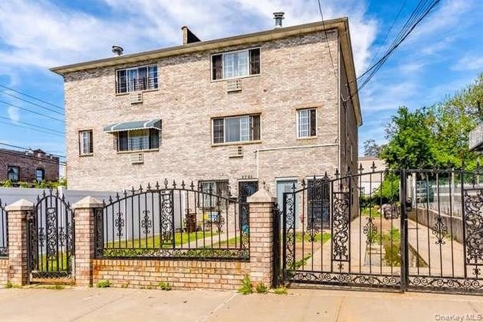 Front of structure with Gate and a fenced front yard