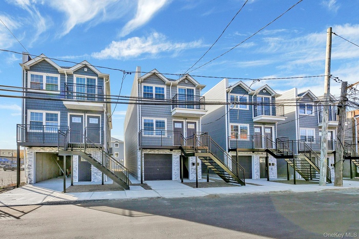 Coastal inspired home featuring stairs and an attached garage