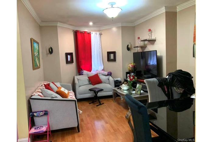 Living area featuring wood finished floors and crown molding