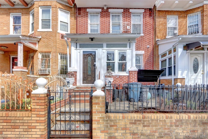 View of front of property with a gate, a fenced front yard, and brick siding