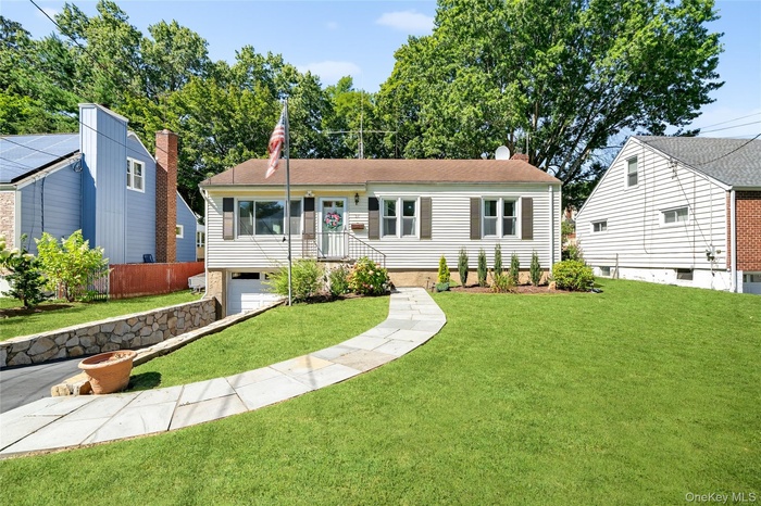 Ranch-style home featuring a garage, a front yard, and a chimney