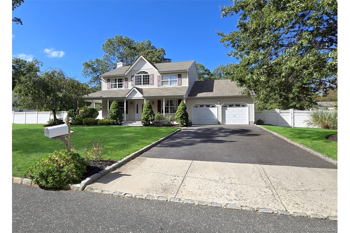 View of front of home featuring a porch, asphalt driveway, a chimney, an attached garage, and roof with shingles