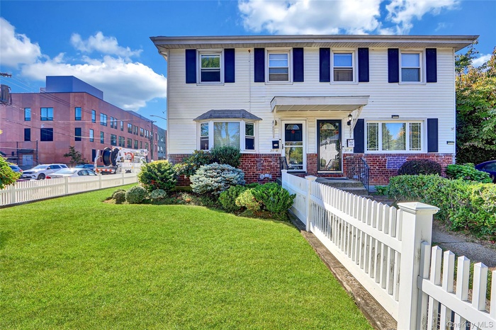 View of front facade with a fenced front yard and brick siding